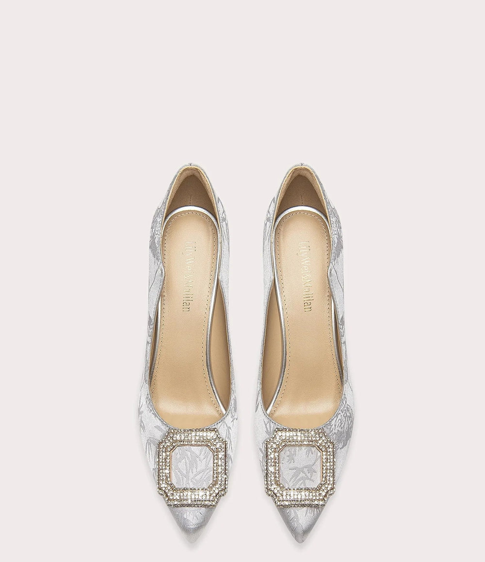 Pair of silver high-heeled shoes with intricate patterns on a white background