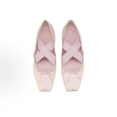 Pair of pink ballet shoes with ribbons on a white background