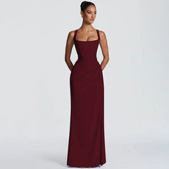 Woman wearing a burgundy evening gown on a light gray background