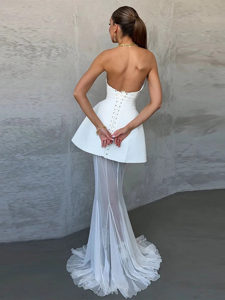 Woman wearing a white wedding dress with a lace-up back against a neutral background