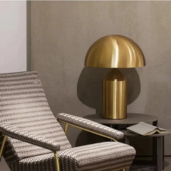  Lifestyle image of the gold mushroom table lamp illuminating a cozy bedroom or living room. Golden Atelier 2