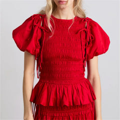 Red dress with puff sleeves on a plain background