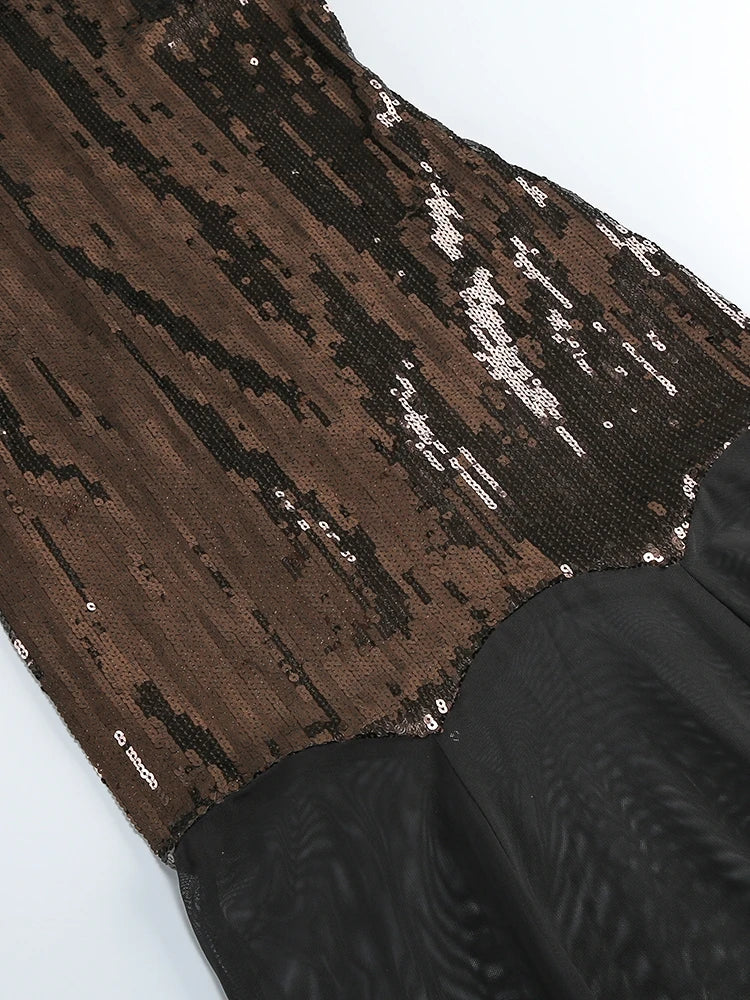 Close-up of a brown and black patterned fabric with sequins on a white background