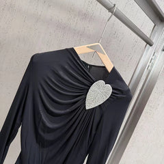Close-up of heart rhinestone embellishment on black bodysuit