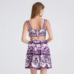 Woman wearing a purple and white patterned outfit on a plain background