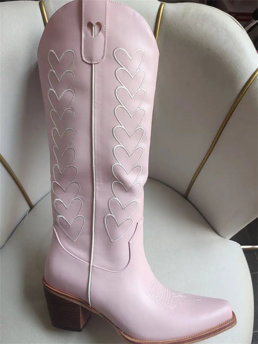 Pink cowboy boot with heart designs on a white chair
