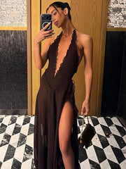 Woman taking a mirror selfie wearing a brown dress with a high slit in a room with black and white checkered floor.