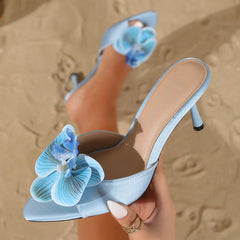 Light blue orchid embellished satin stiletto heels on sand