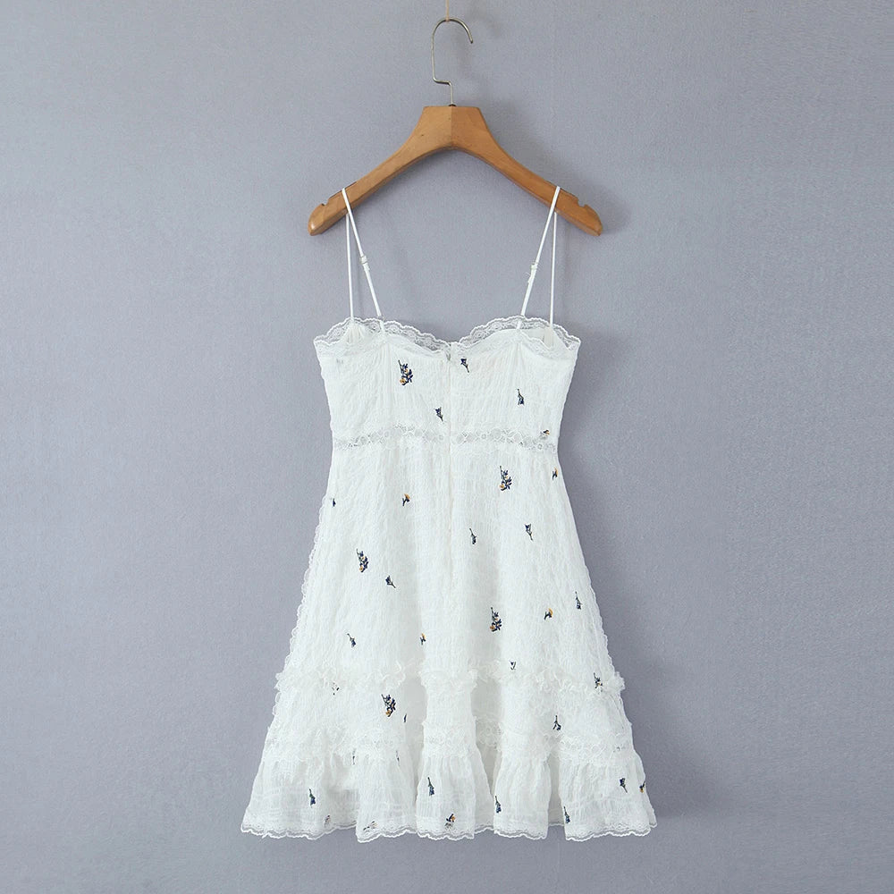 White lace dress on a wooden hanger against a gray background