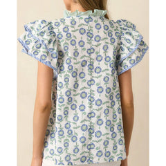 Floral patterned blouse with ruffled sleeves on a beige background