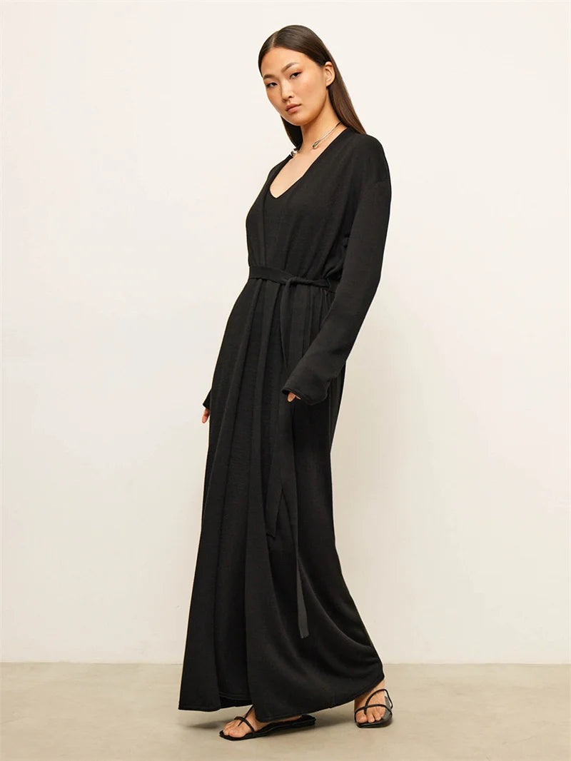 Woman wearing a black dress against a plain background