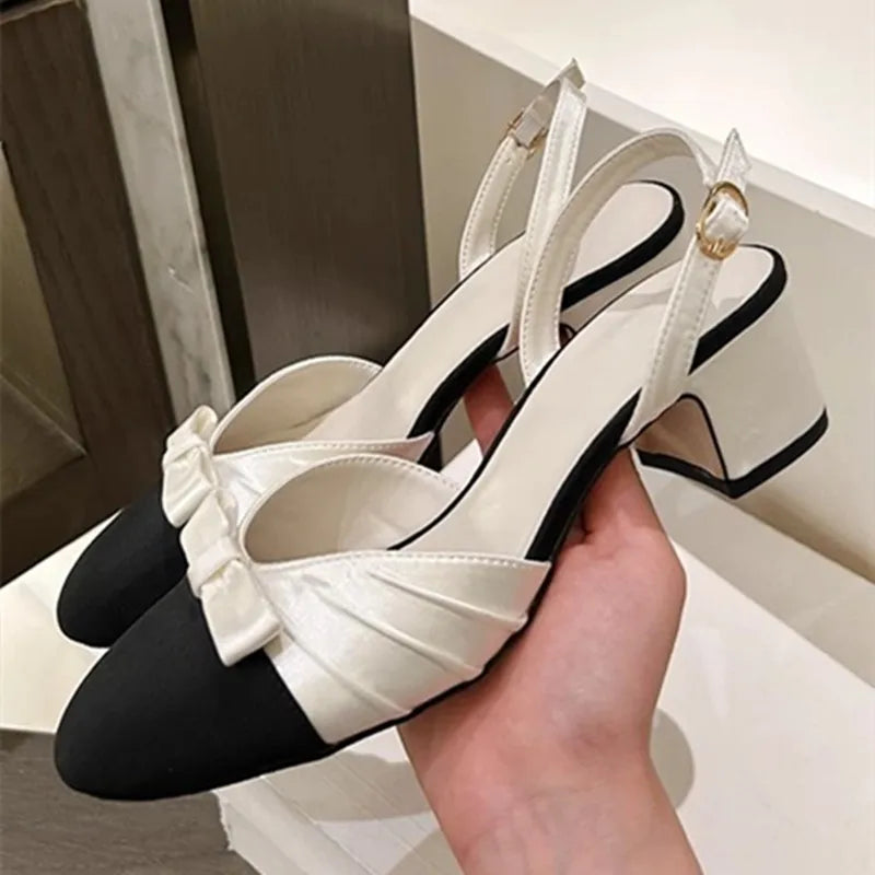 White bow slingback mid heel pumps held