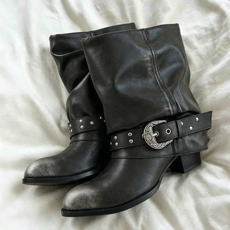 Black slouch ankle boots with a distressed toe cap and a studded buckle strap.