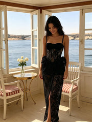 Black lace corset gown with a side split, modeled by a woman looking down.