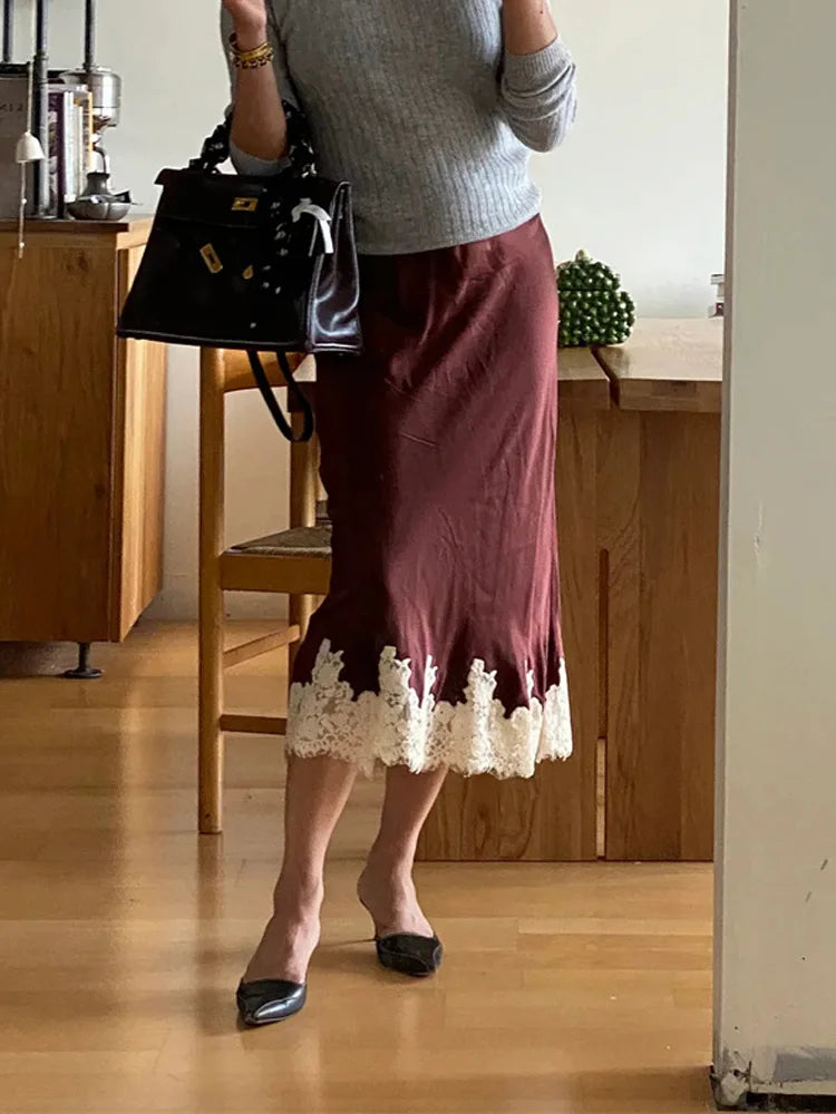 Person wearing a maroon skirt with lace trim in an indoor setting.