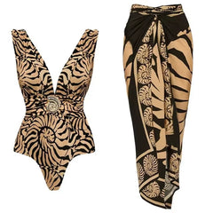 Tan and black animal print textured one-piece swimsuit with gold-tone embellishment and a matching tan and black wrap skirt with a seashell-inspired print.