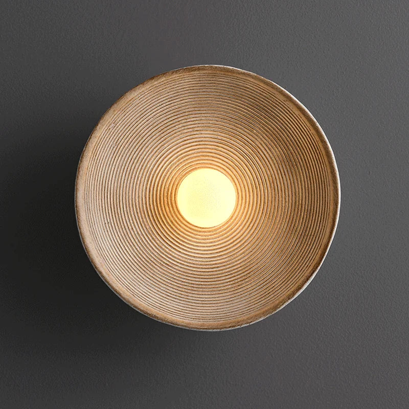 Close-up of a Wabi-Sabi wall lamp, highlighting its natural materials and circular design. A