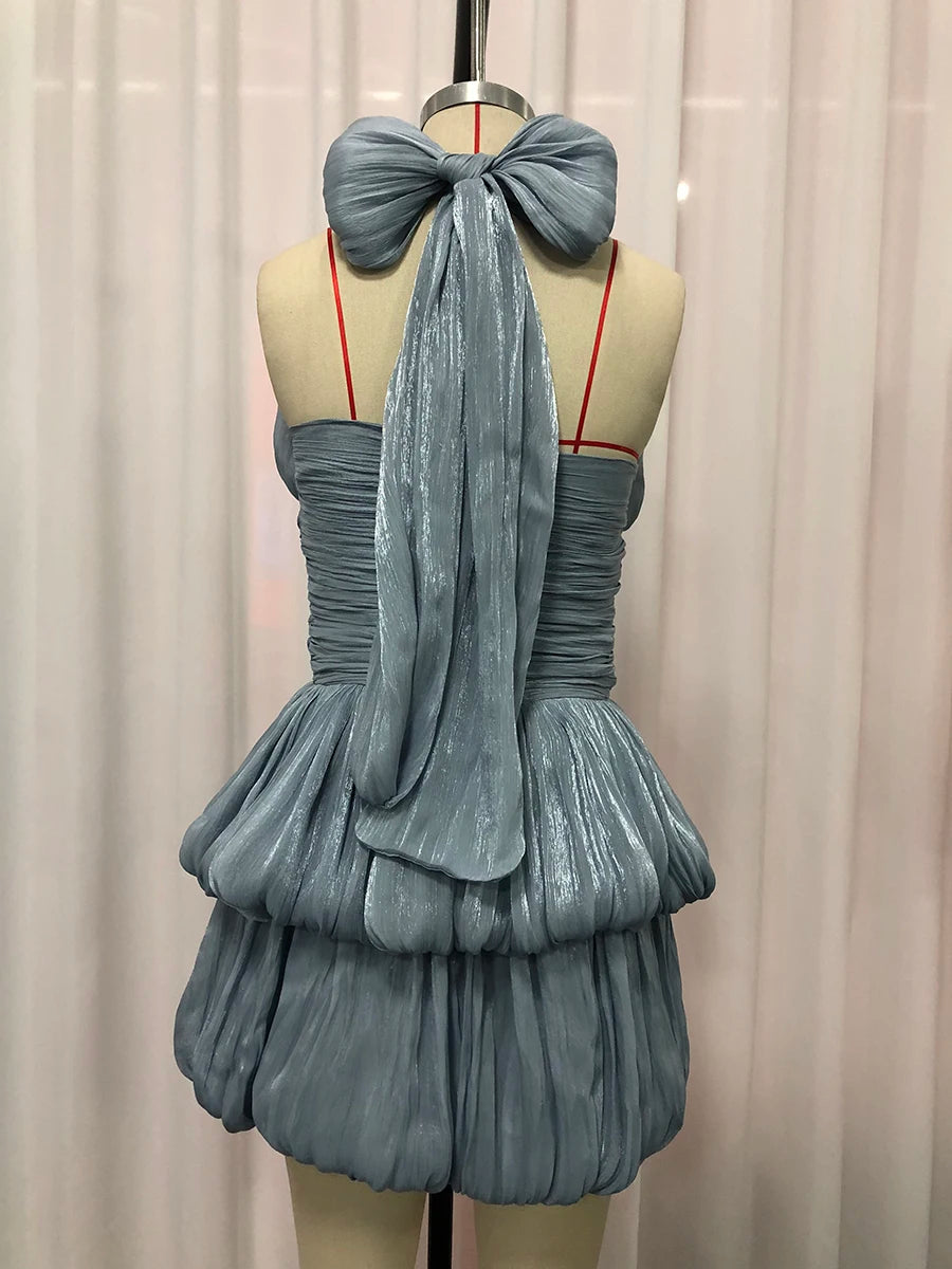 Blue dress on a mannequin against a white curtain background