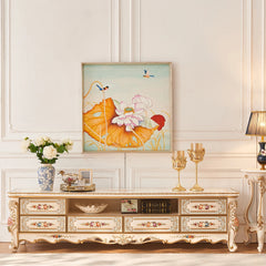 Decorative TV stand with floral design, framed artwork, and candles in a room.