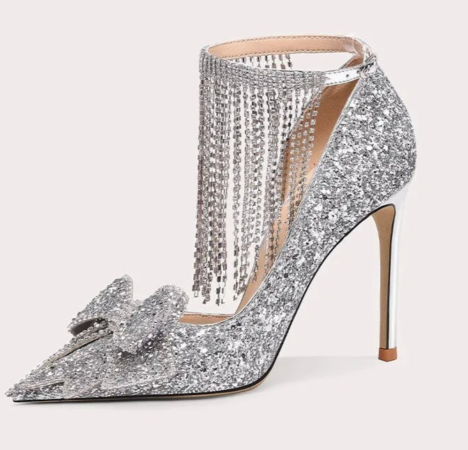 Silver high-heeled shoe with decorative elements on a white background
