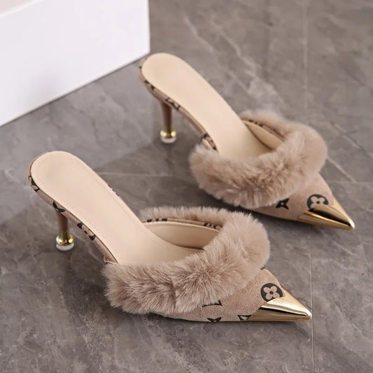 Beige faux fur trim pointed heel mules with metallic toe cap and monogram print.