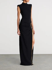 Black evening gown with a high slit on a plain background