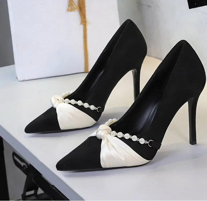 Black pointed toe pumps with bow and pearl detail