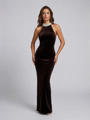 Woman wearing a brown evening gown with a high neckline on a gray background