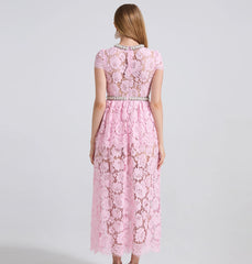 Pink lace dress with embellishments on a gray background