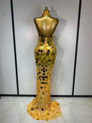 Gold evening gown on a mannequin against a white wall