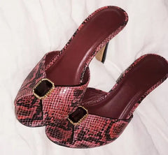 Pair of pink snakeskin print mule heels with gemstone detail