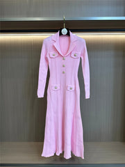 Pink dress with buttons on a hanger against a neutral background
