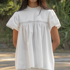 White blouse with lace details worn by a person outdoors