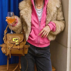Model wearing a fur coat and pink hoodie with a brown PU leather backpack.