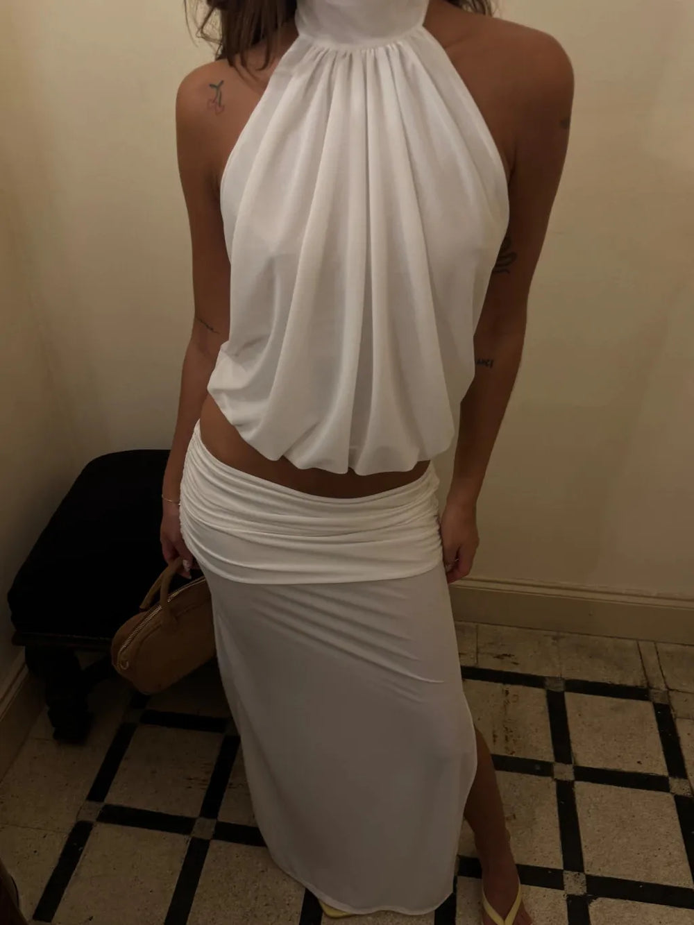 Close-up of white halter crop top and ruched maxi skirt set