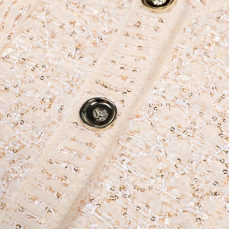 Close-up of a textured beige fabric with a button