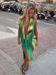 Woman wearing a printed halter fringe maxi dress outdoors on a sidewalk