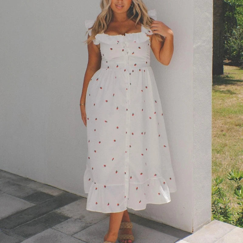 Woman wearing a white dress with red polka dots against a neutral background