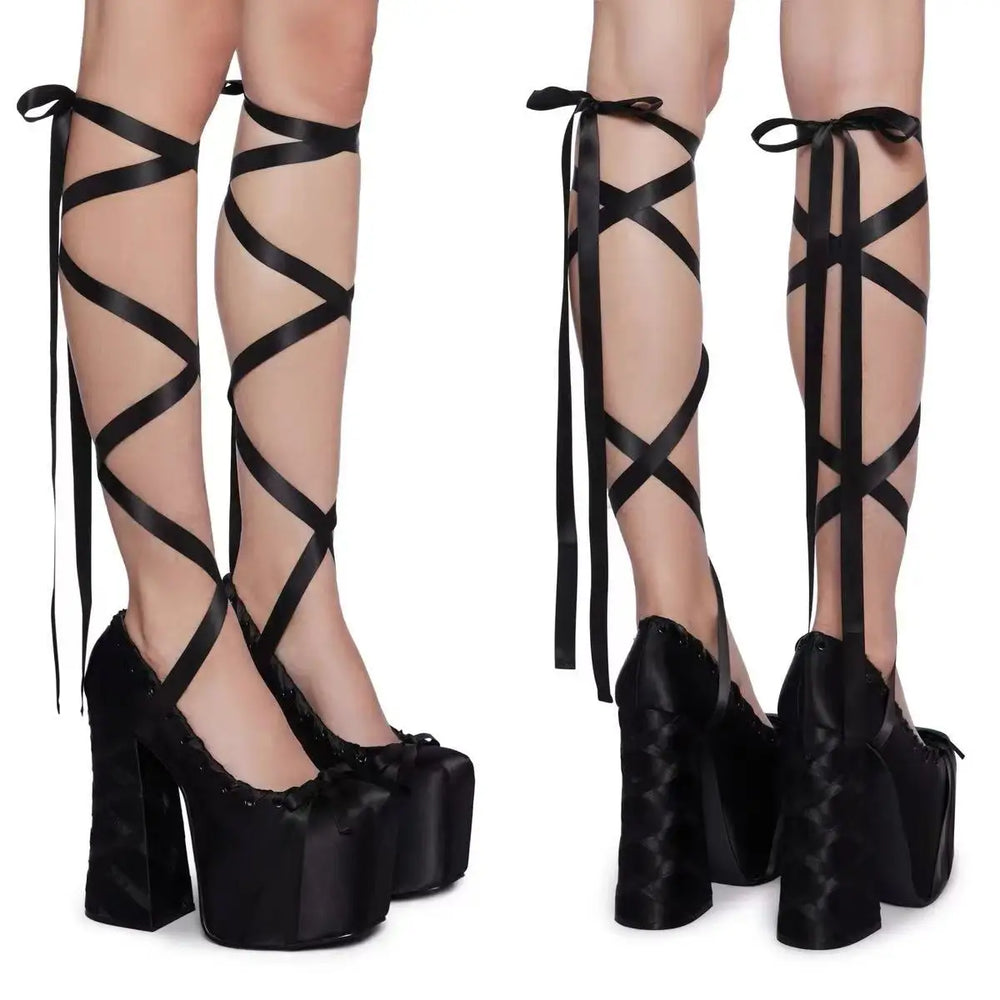 Black strappy high-heeled shoes with platform soles on a white background