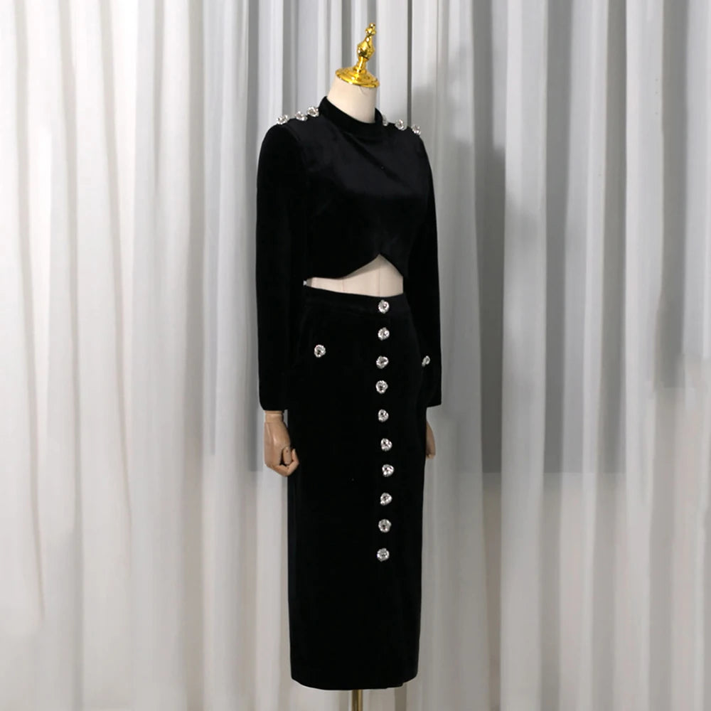 Full view of a black velvet embellished crop top and high-slit midi skirt on a mannequin.