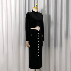 Full view of a black velvet embellished crop top and high-slit midi skirt on a mannequin.