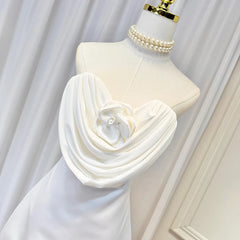 White strapless mini dress on mannequin with sculpted rose applique and draped front