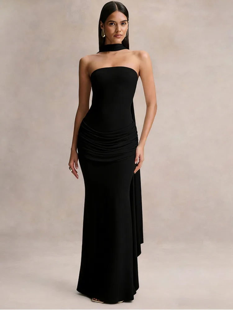 Woman wearing a black strapless gown against a neutral background