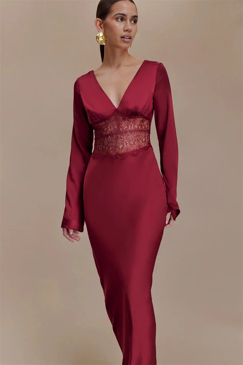 Woman wearing a burgundy evening gown with lace detailing on a beige background