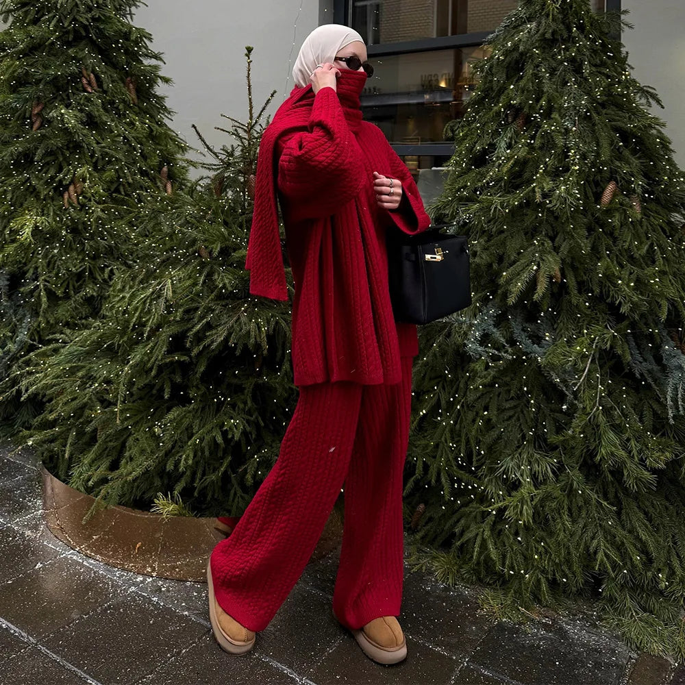 Person in a red outfit standing between two decorated Christmas trees.