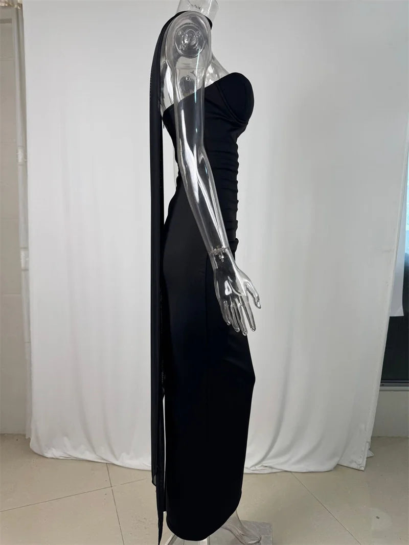 Black evening gown on a transparent mannequin against a white curtain background