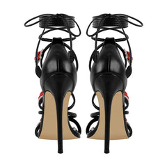 Back view of black lace-up stiletto heeled sandals with rose details.