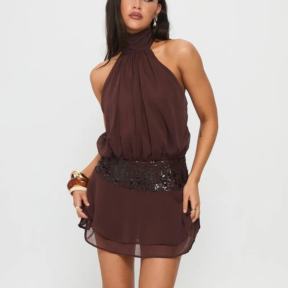 Woman wearing a brown halter neck dress with sequin details on a white background