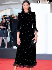 Woman in a black dress with white polka dots on a red carpet