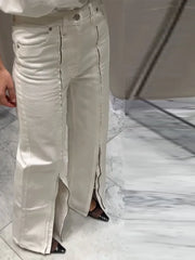 Beige pants worn by a person on a marble floor